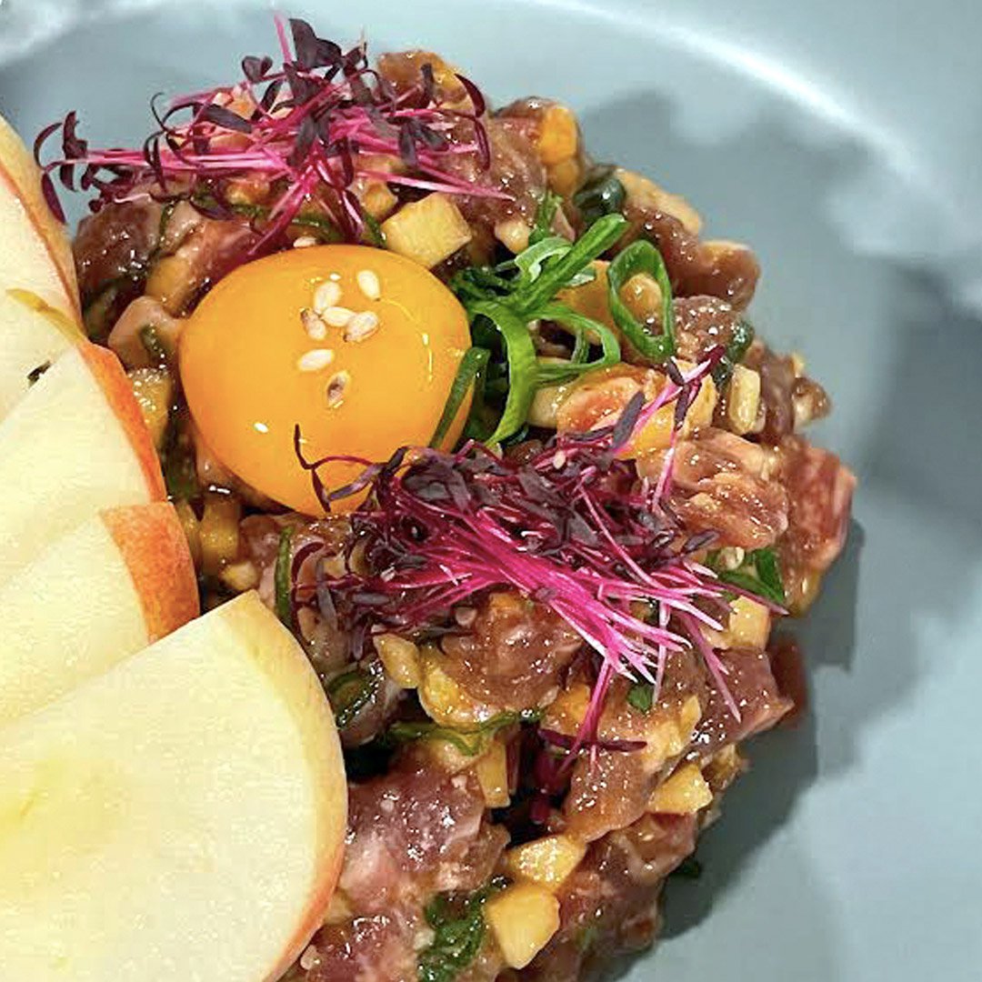 Tartare de puyaso con brunoise de manzana, cebollin, ajonjolí tostado, pistachio y yema de huevo con una salsa hecha a base de salsa soya y jugo de pera coreana.