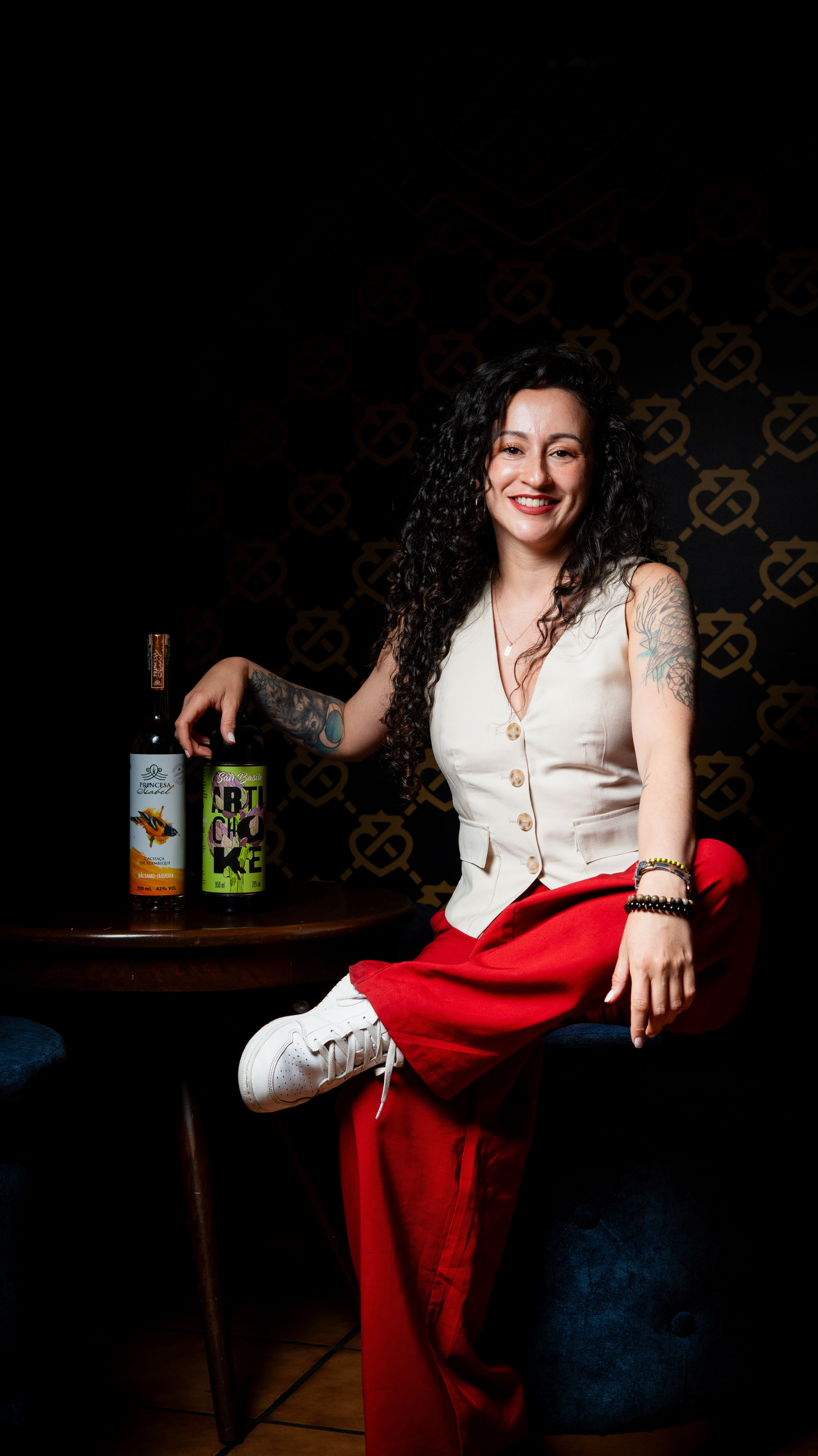 Ana Paula Ulrich junto al destilado brasileño Cachaça y el amaro Cynar / Imagen cortesía de Andrés Viana